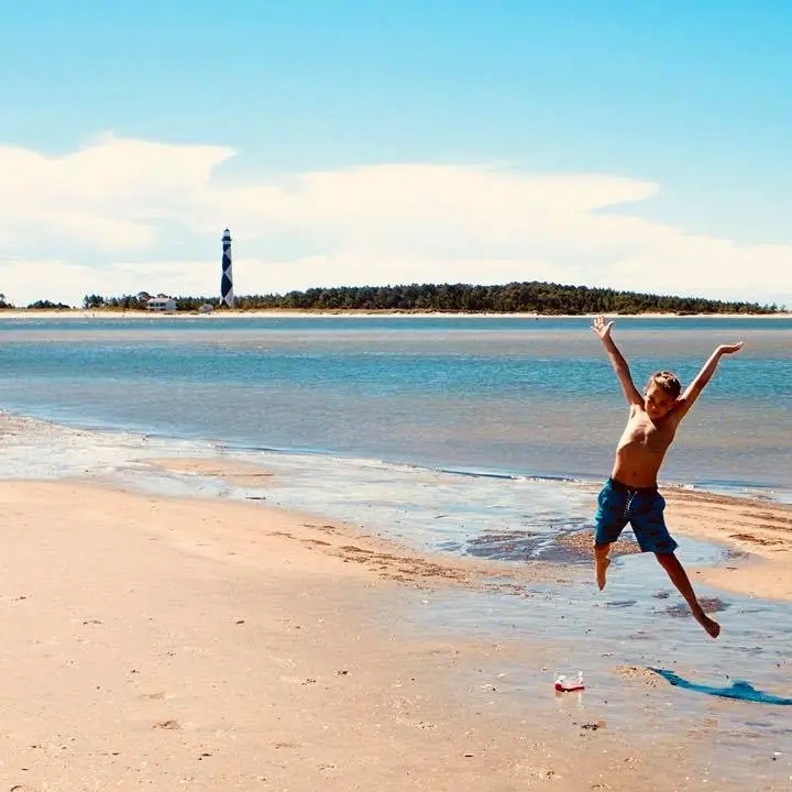 boy jumping for joy on beach
