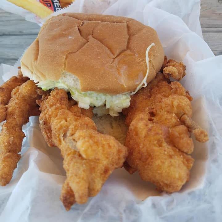 a sandwich sitting on top of a pile of food